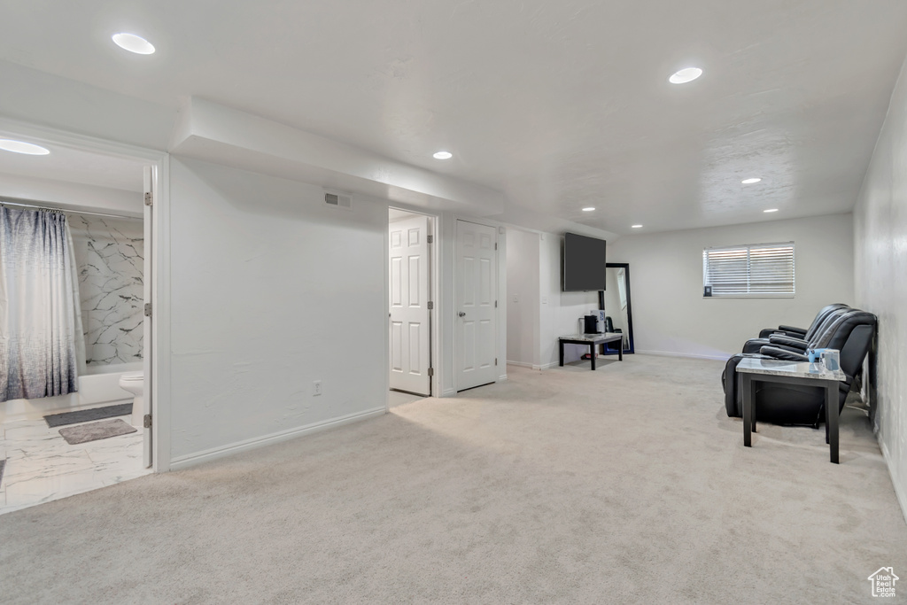 Living area with recessed lighting and light colored carpet