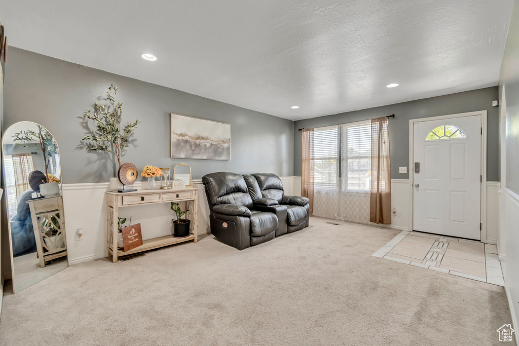 Living area featuring carpet floors, a wainscoted wall, and recessed lighting