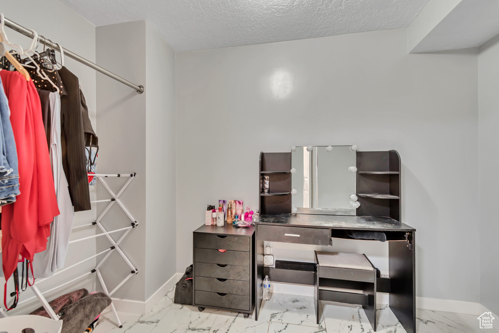 Spacious closet featuring marble look tiles