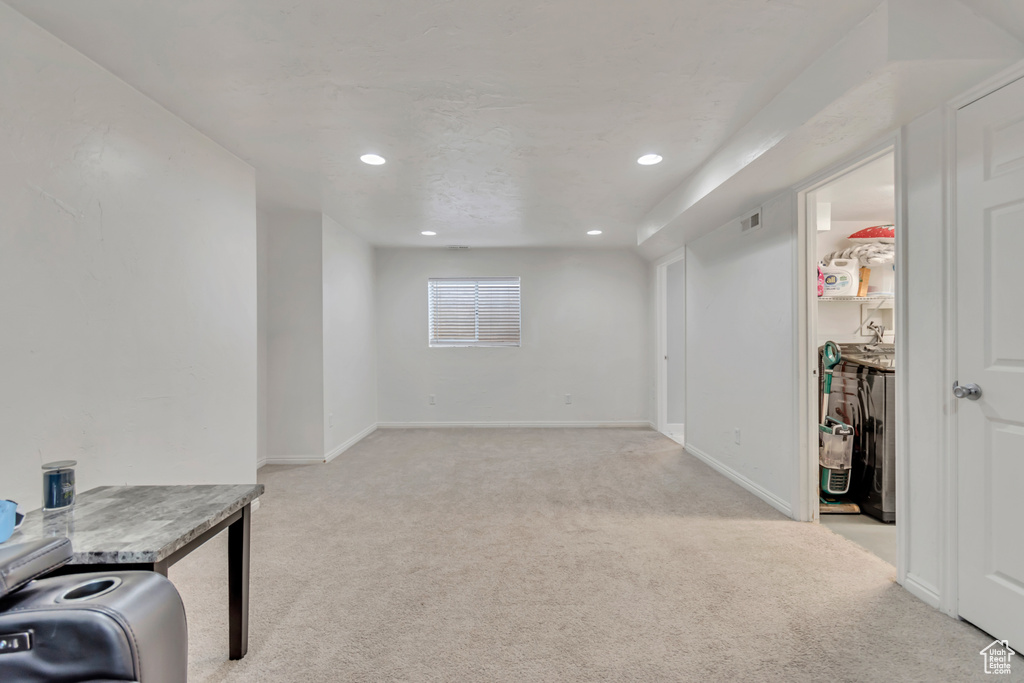 Below grade area with light carpet and recessed lighting
