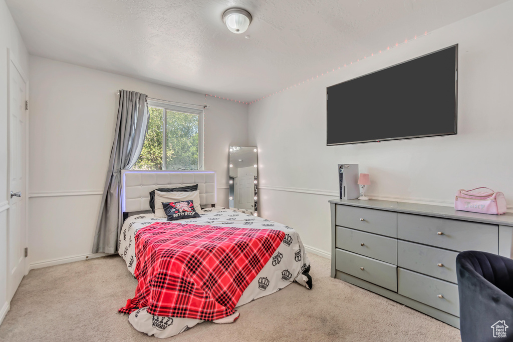 Bedroom featuring carpet and baseboards