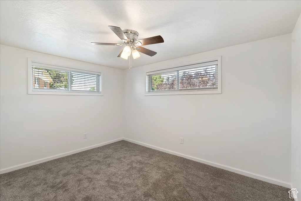Spare room featuring carpet flooring and ceiling fan