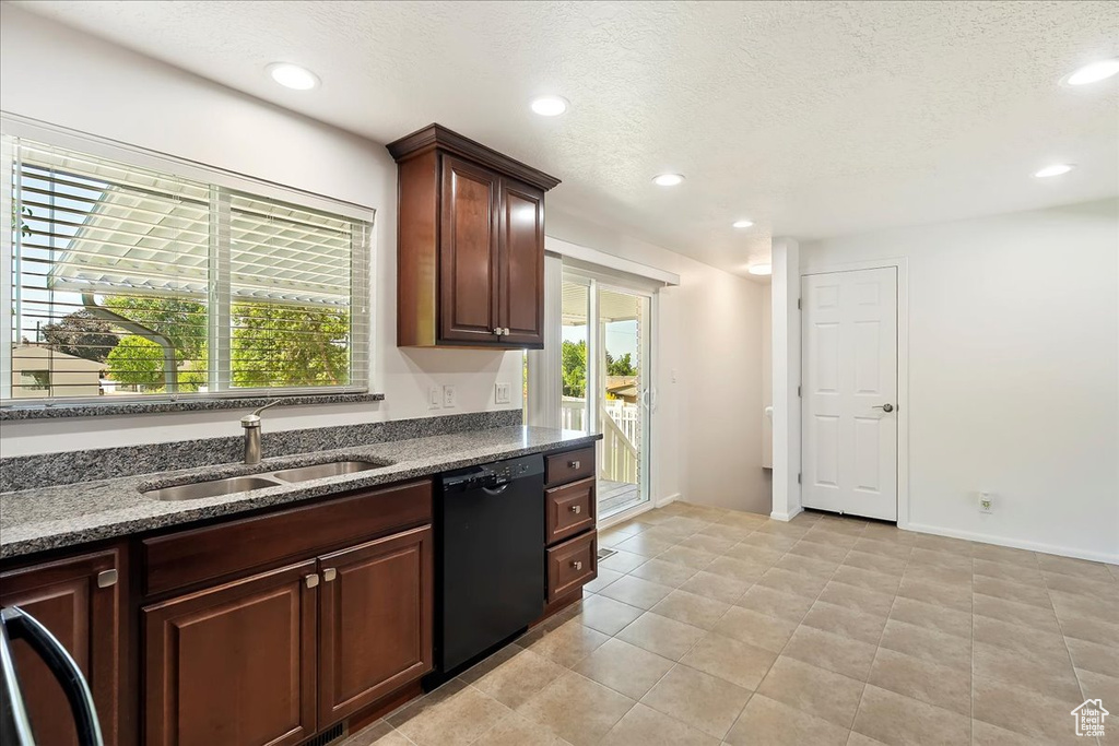 Kitchen featuring black dishwasher, dark stone counters, recessed lighting, light tile patterned flooring, and a textured ceiling