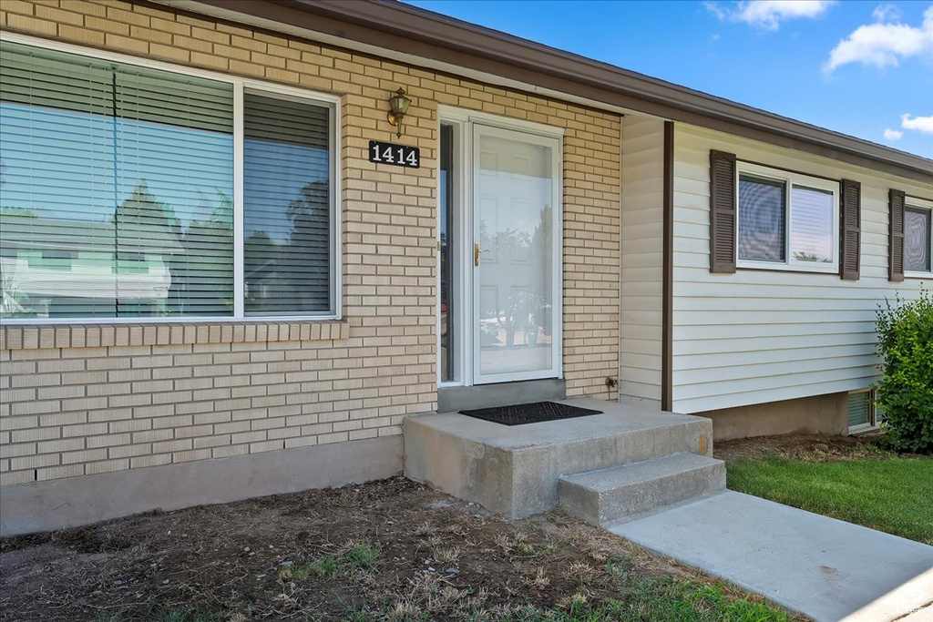 Property entrance featuring brick siding