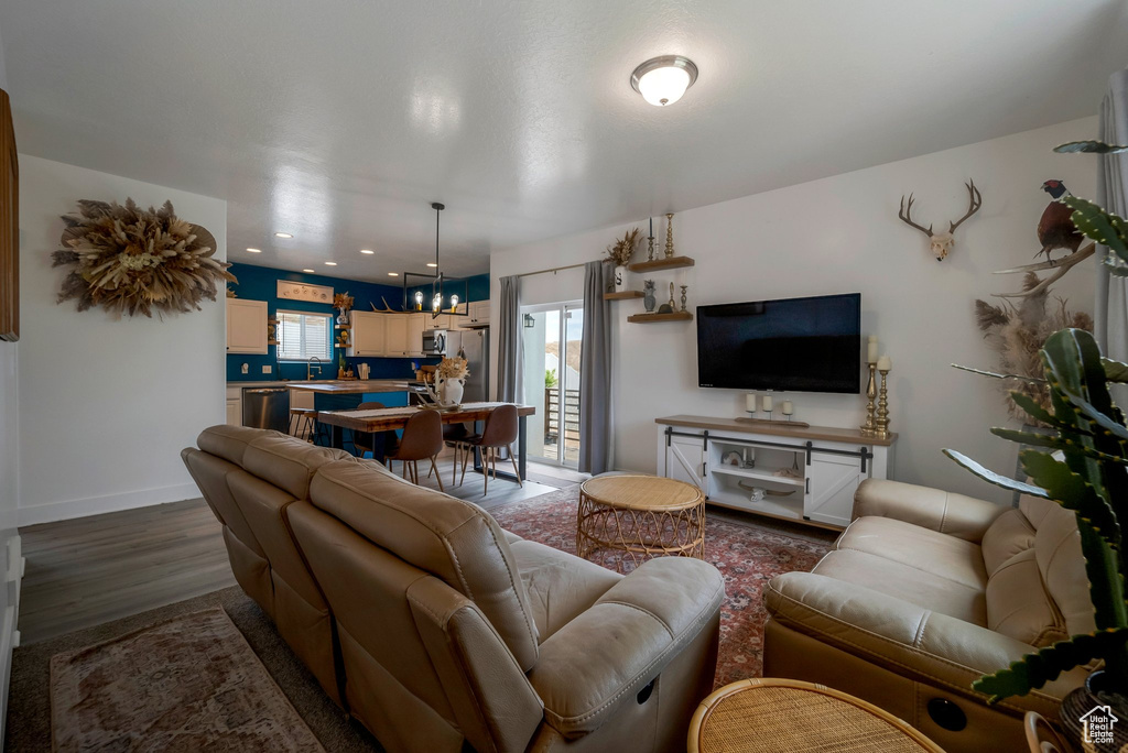 Living area featuring a chandelier and dark wood-type flooring