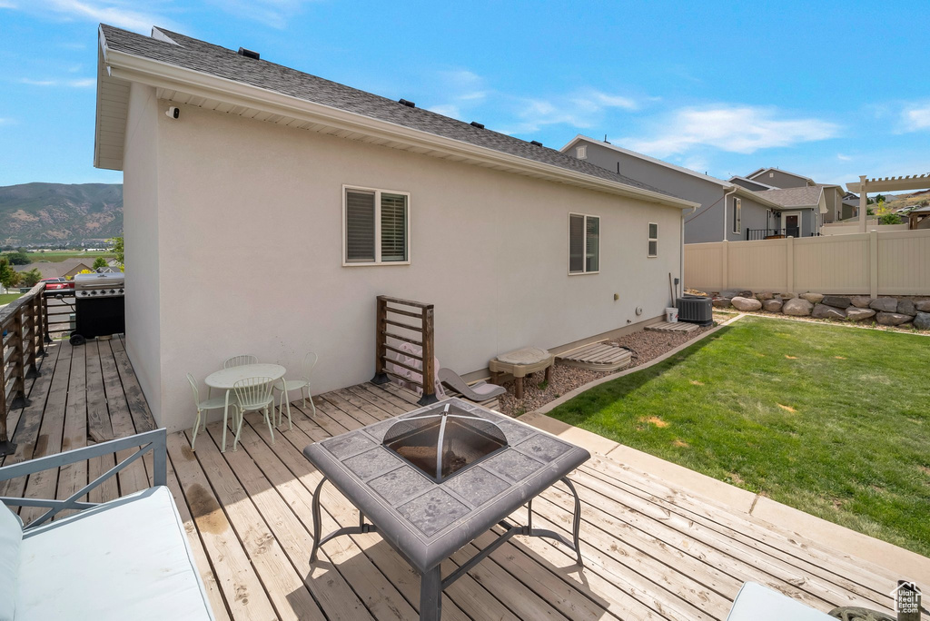 Wooden terrace featuring a fire pit and grilling area
