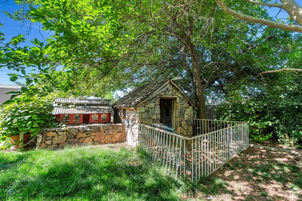 View of front of house with stone siding and a shed