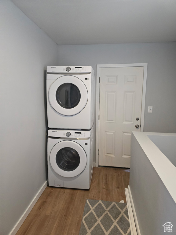 Laundry area with stacked washer / dryer and dark wood finished floors