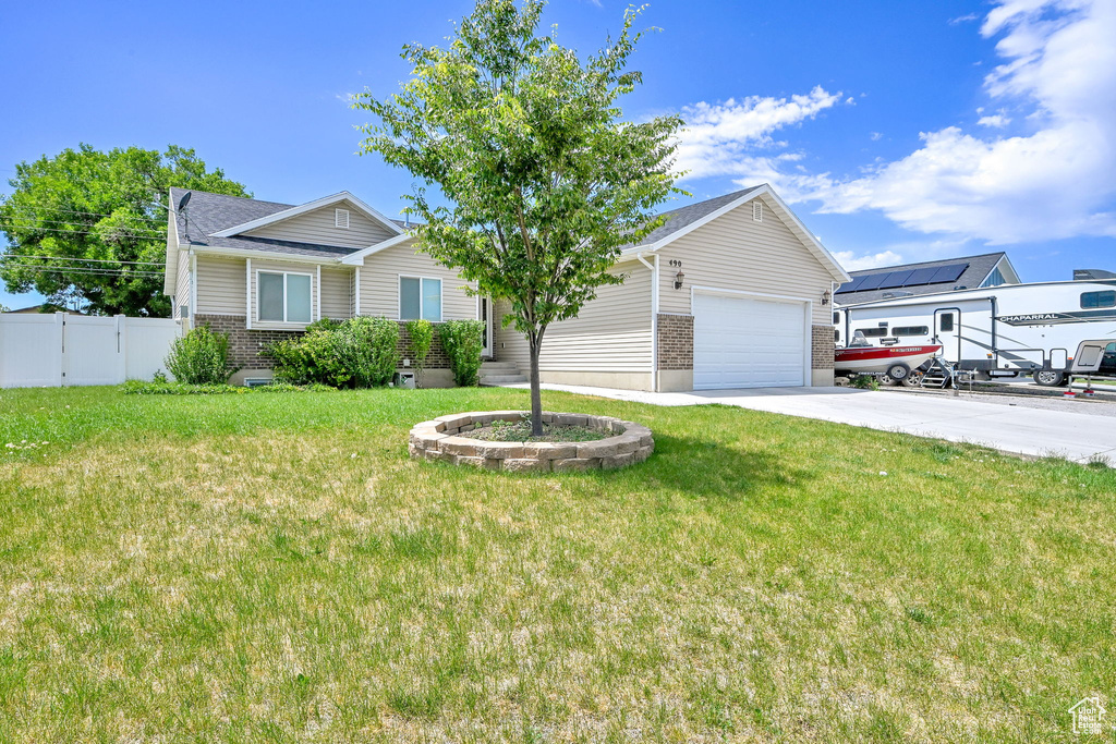 Single story home featuring concrete driveway, an attached garage, and brick siding