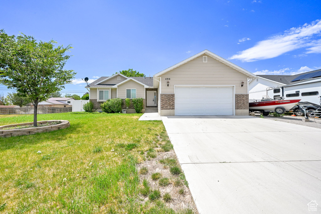 Ranch-style home with concrete driveway and an attached garage