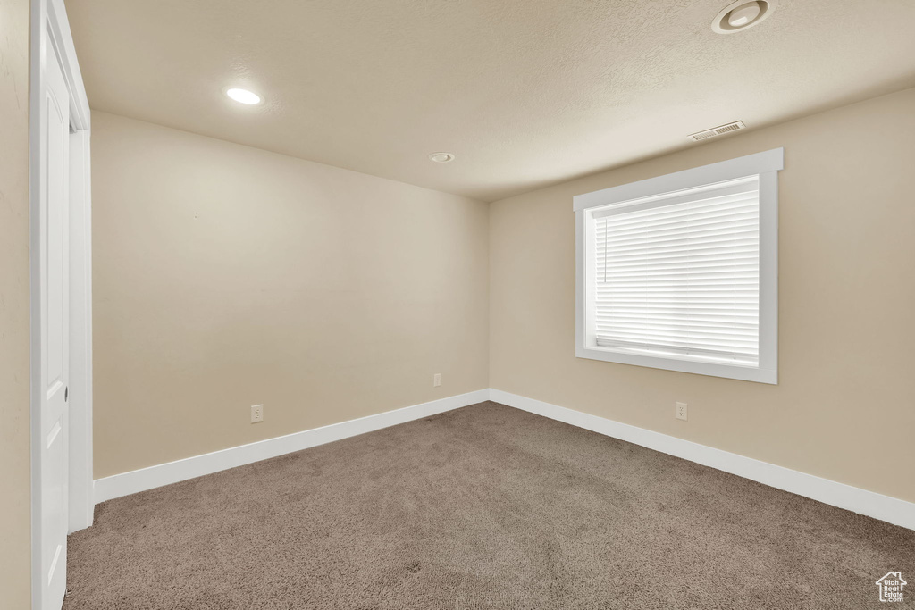 Unfurnished room featuring dark carpet and recessed lighting