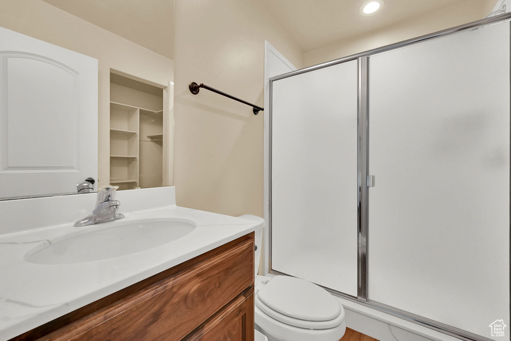 Bathroom with a stall shower, vanity, and recessed lighting