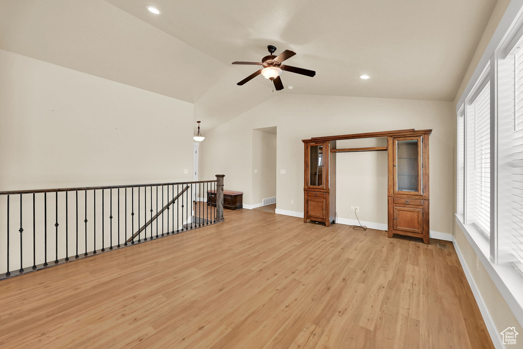 Empty room featuring ceiling fan, light wood-type flooring, vaulted ceiling, and recessed lighting