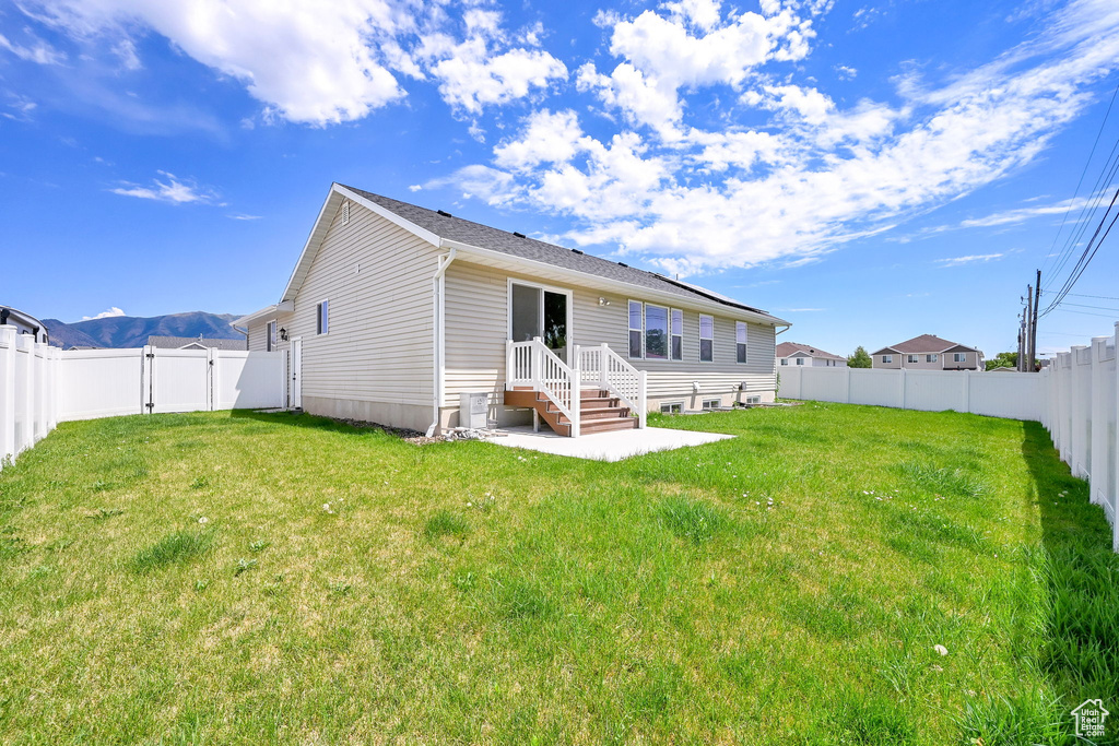 Back of house with a fenced backyard and a gate