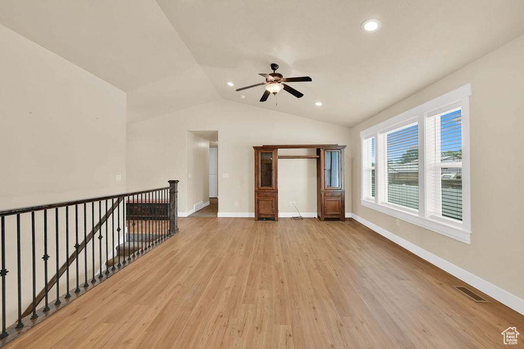 Empty room with a ceiling fan, light wood-style floors, recessed lighting, and lofted ceiling