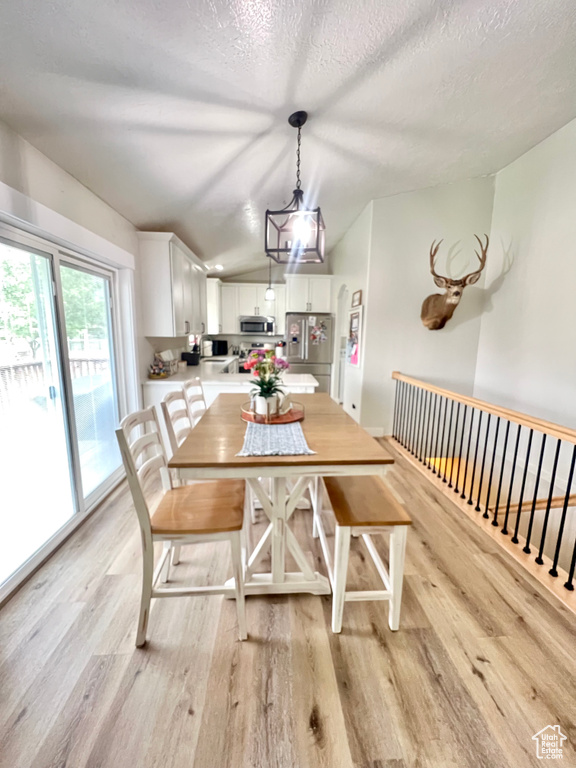 Dining room featuring light wood-style flooring and a textured ceiling