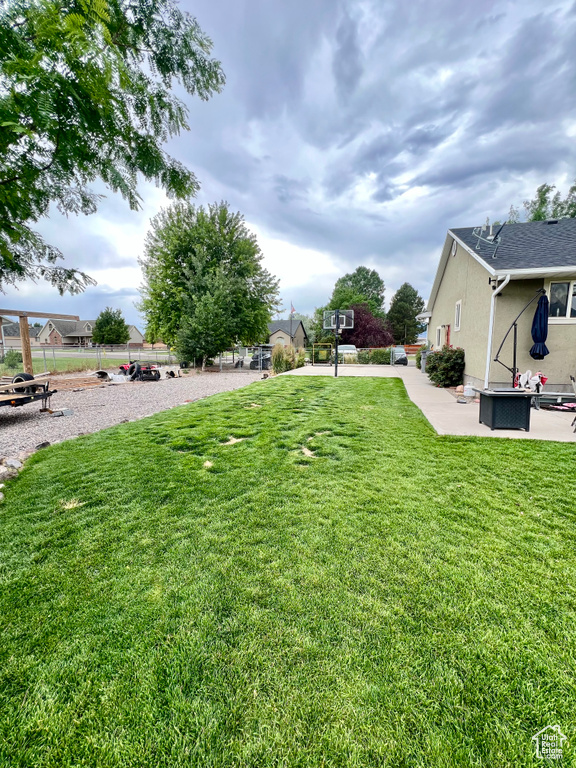 View of grassy yard featuring a patio area