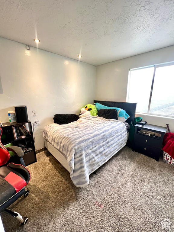 Carpeted bedroom with a textured ceiling and recessed lighting