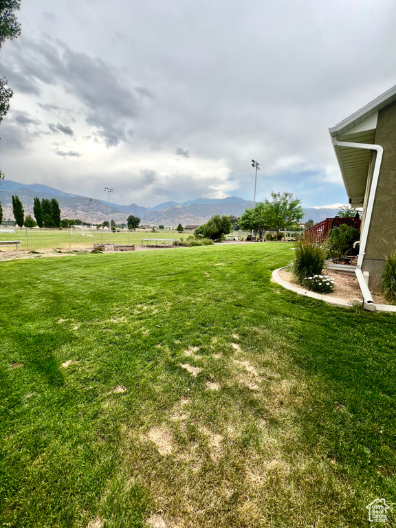 View of green lawn with a mountain view and a view of rural / pastoral area