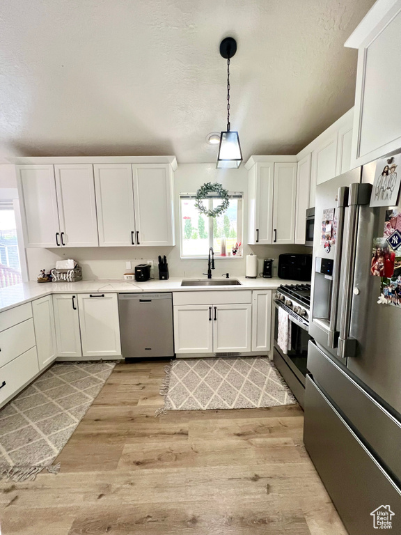 Kitchen featuring stainless steel appliances, plenty of natural light, and white cabinets