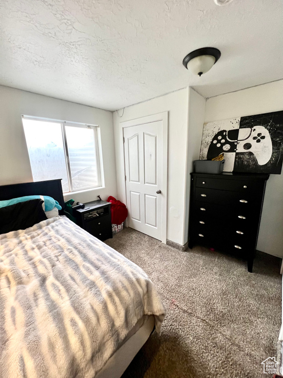 Bedroom featuring carpet floors and a textured ceiling