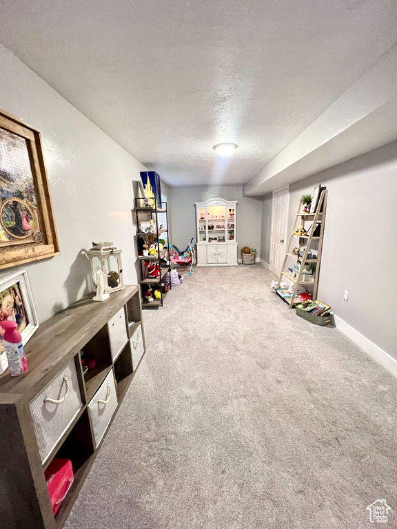 Rec room with carpet and a textured ceiling