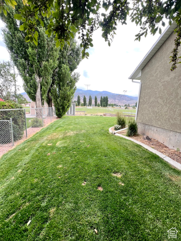 View of yard with a mountain view, a storage unit, and a view of countryside