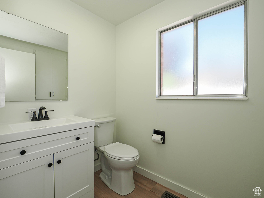 Half bathroom featuring wood finished floors and vanity