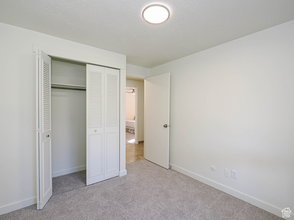 Unfurnished bedroom featuring carpet floors and a closet