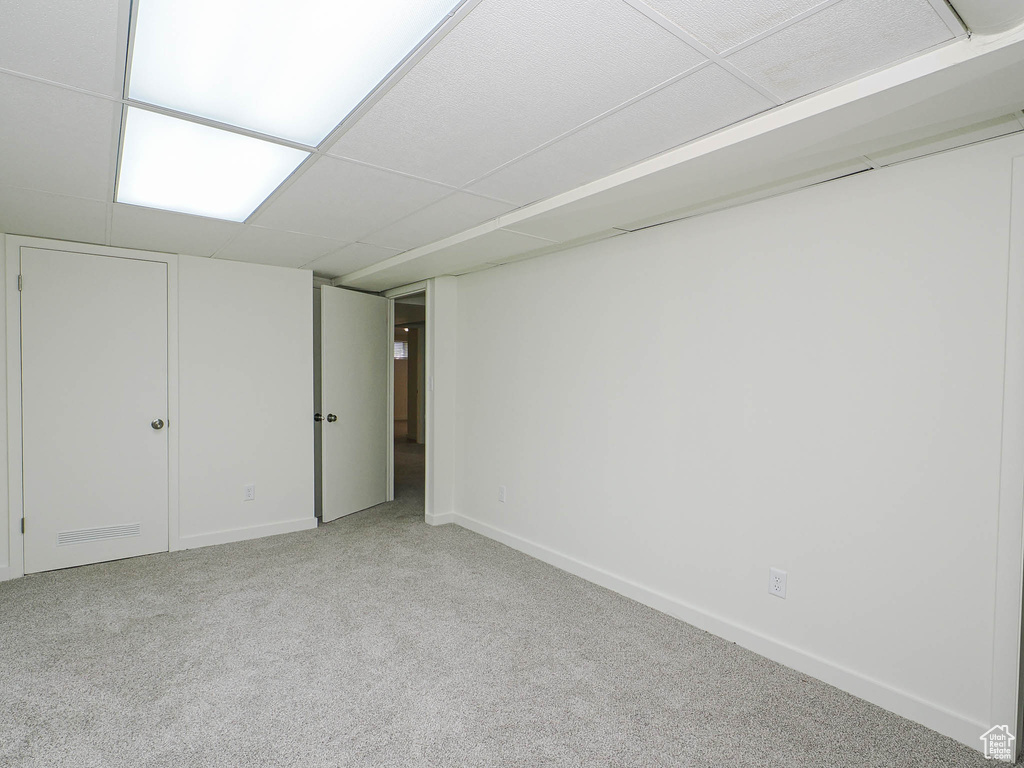 Finished below grade area featuring light carpet and baseboards