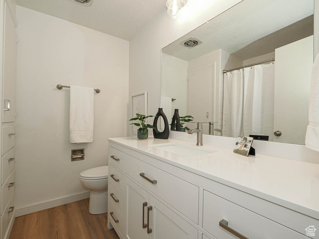 Full bath with wood finished floors and vanity