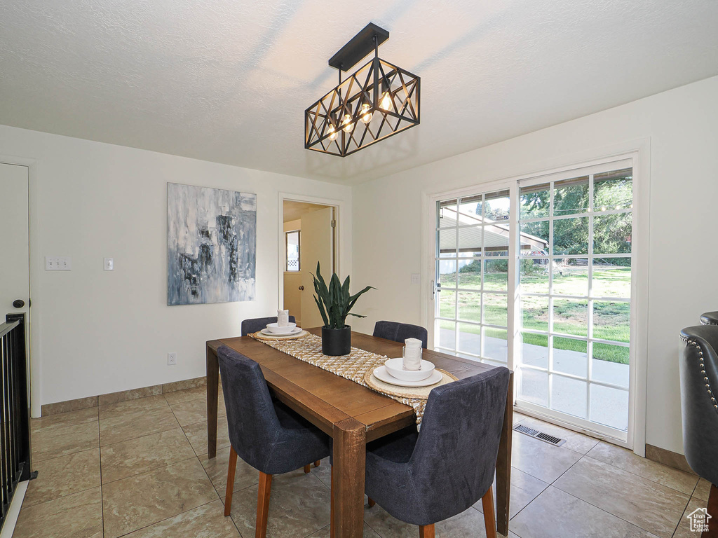 Dining area featuring baseboards and a chandelier