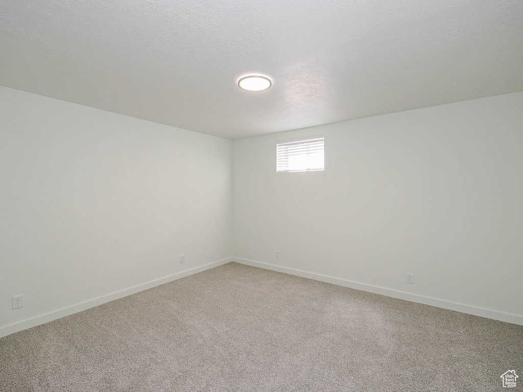 Empty room featuring light colored carpet and baseboards