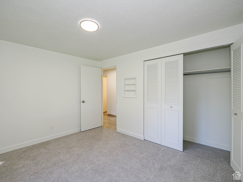 Unfurnished bedroom with a closet and carpet