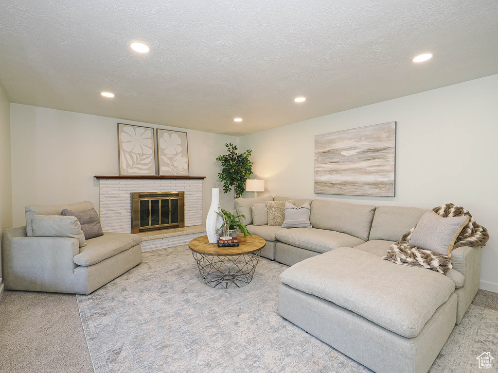 Living area featuring recessed lighting, carpet flooring, and a brick fireplace