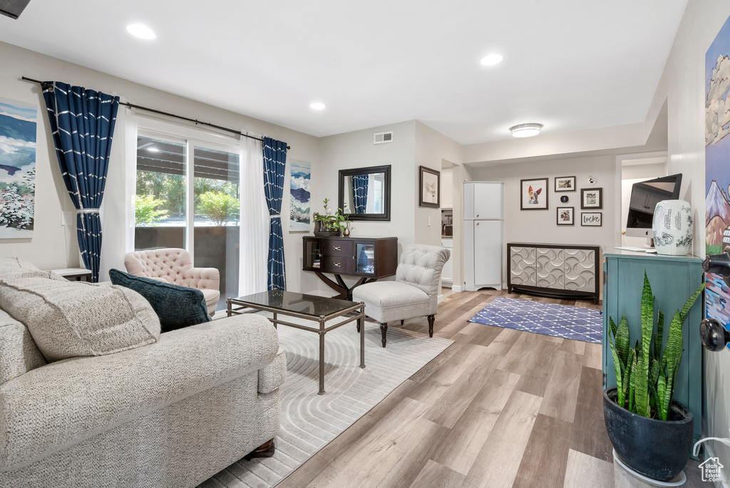 Living area with light wood-style flooring and recessed lighting