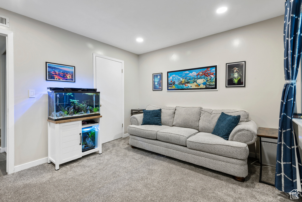 Carpeted living area with recessed lighting and baseboards