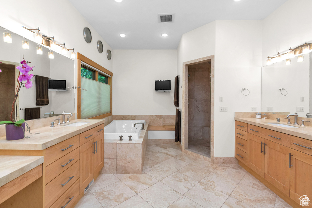 Bathroom with a garden tub, two vanities, a shower stall, and recessed lighting