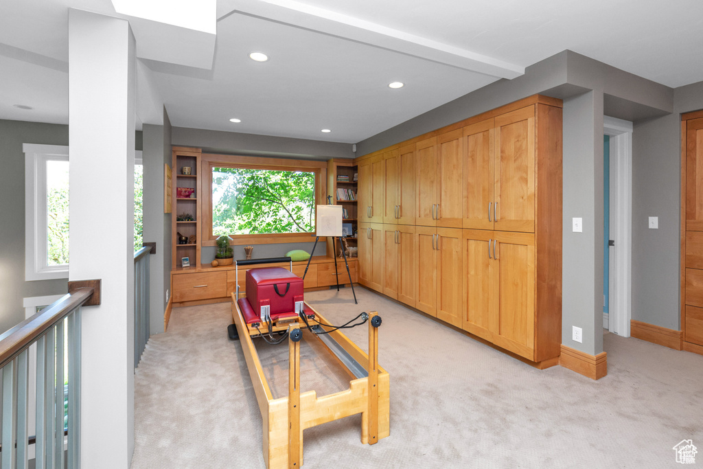 Living area with light carpet, recessed lighting, and an upstairs landing