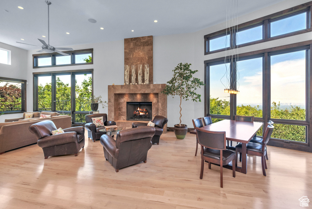 Living room with a ceiling fan, light wood-type flooring, plenty of natural light, a fireplace, and recessed lighting
