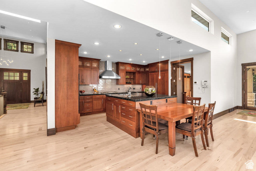 Dining room with a high ceiling, light wood-style flooring, and recessed lighting