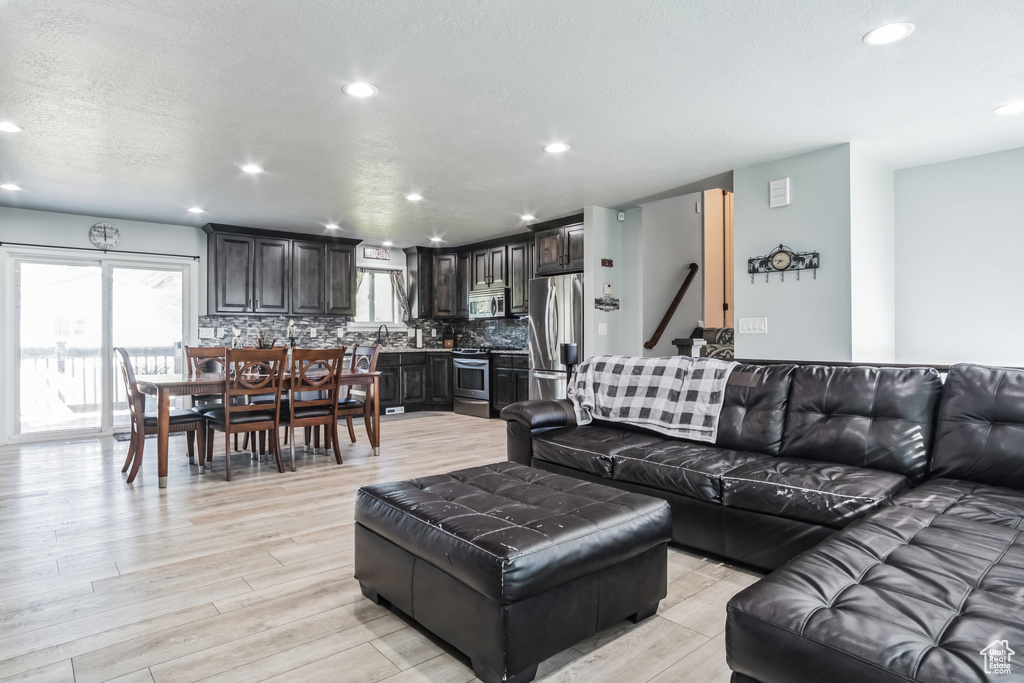 Living area with healthy amount of natural light, recessed lighting, and light wood finished floors