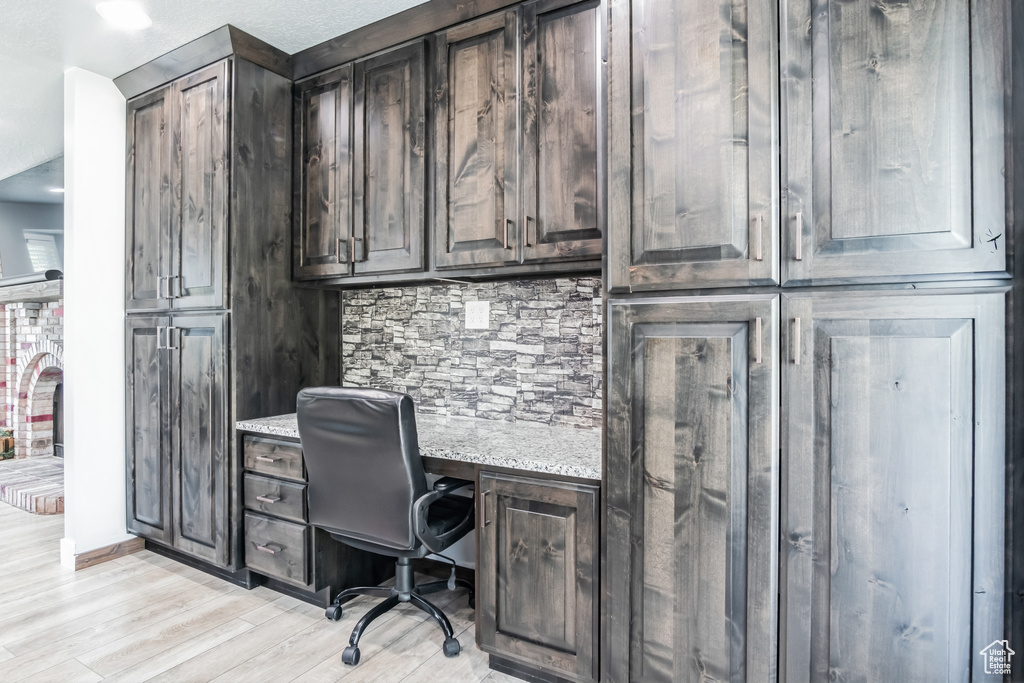 Home office featuring built in desk and light wood-type flooring