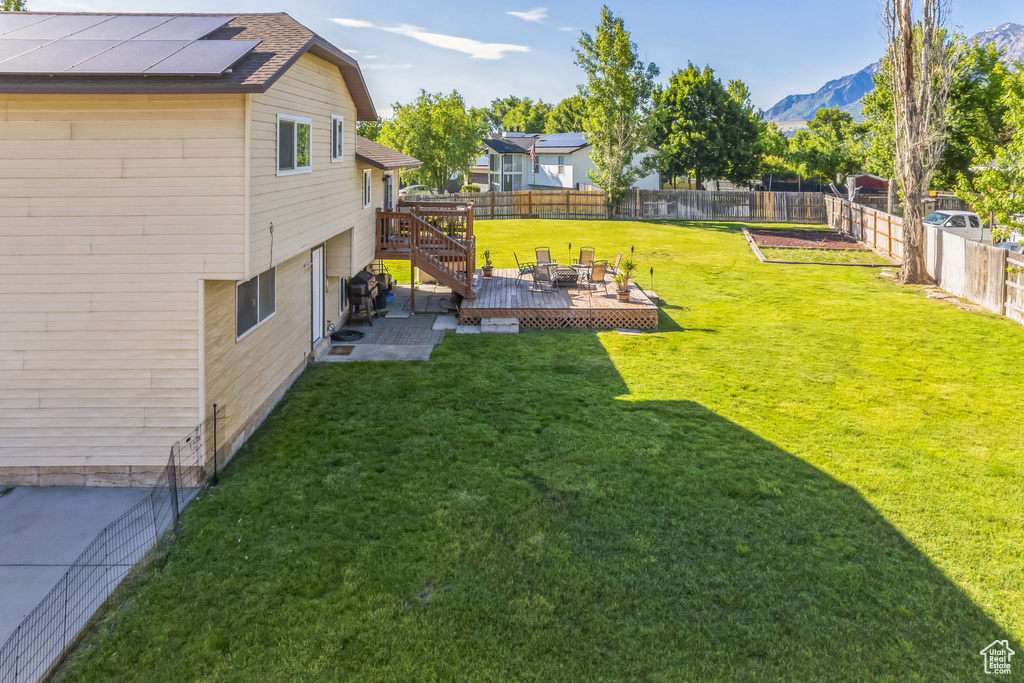 Fenced backyard featuring a deck with mountain view