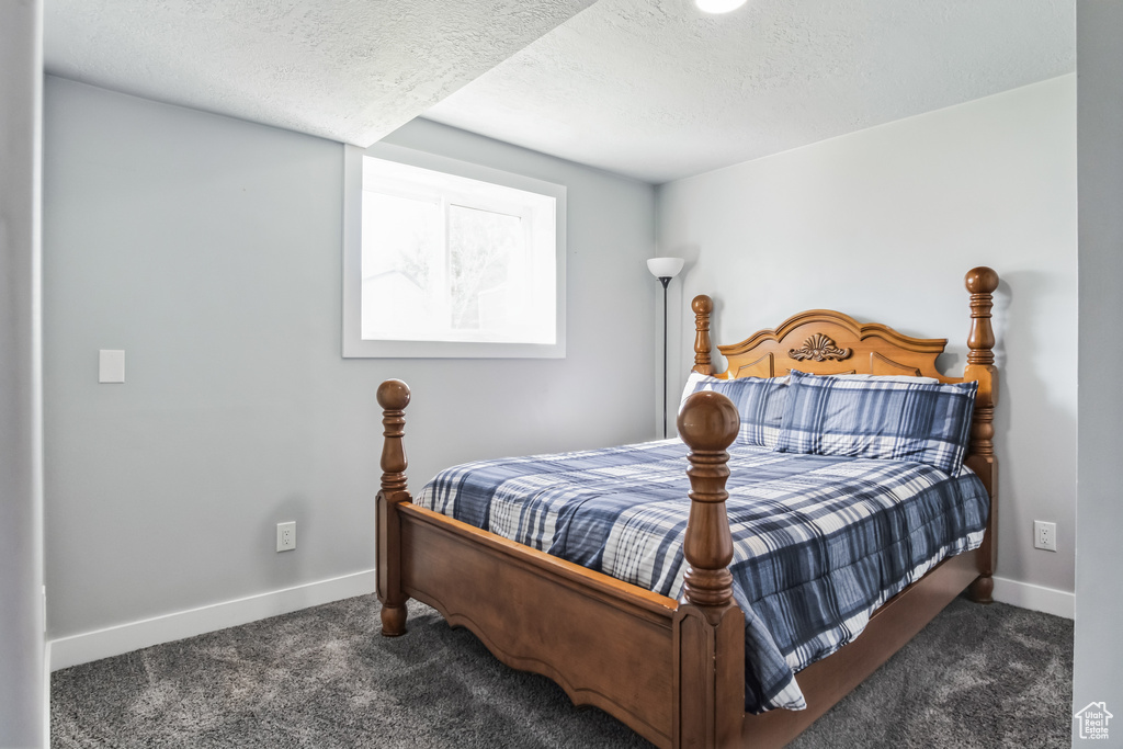 Bedroom featuring carpet and a textured ceiling