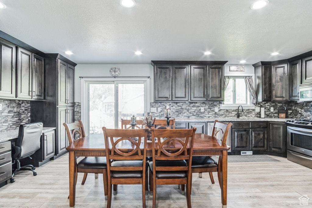 Dining room featuring light wood-style flooring, recessed lighting, and an office area