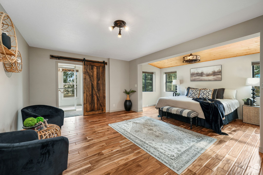 Bedroom featuring a barn door and light wood-type flooring