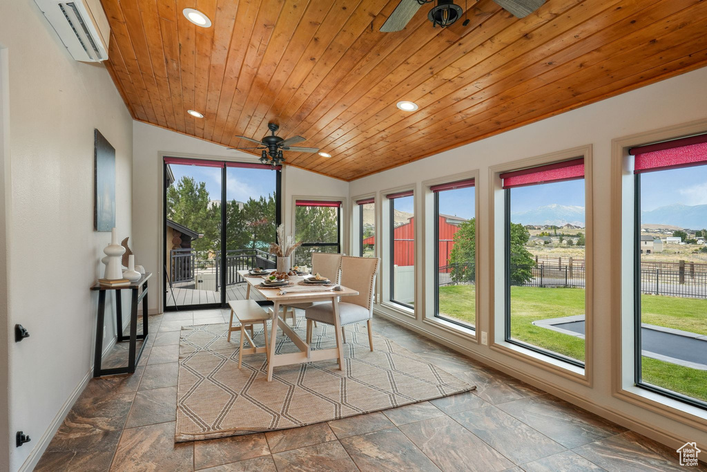 Sunroom with a wall mounted air conditioner and vaulted ceiling