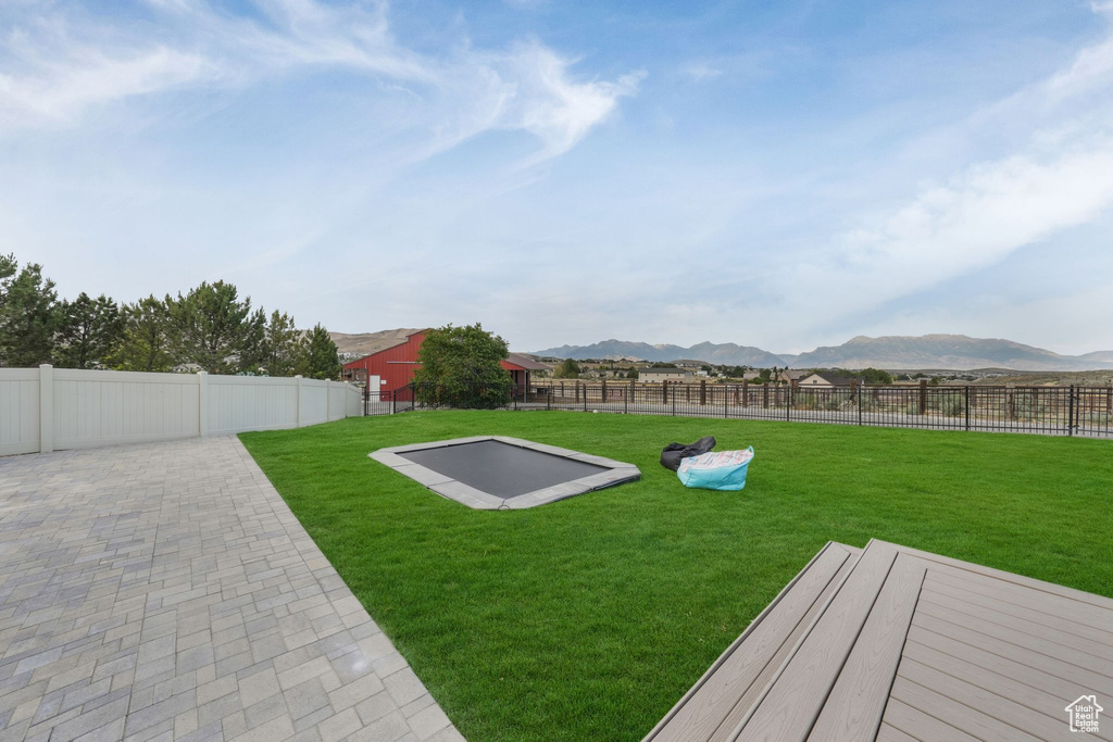 Fenced backyard featuring a mountain view and a patio area