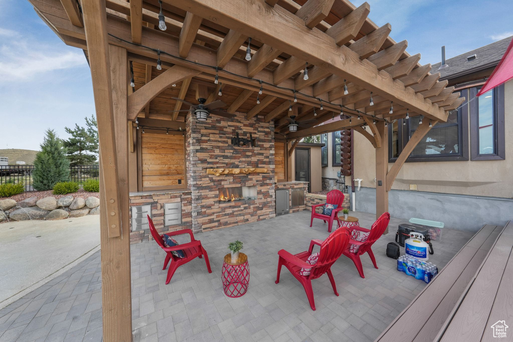 View of patio / terrace featuring an outdoor stone fireplace and a ceiling fan